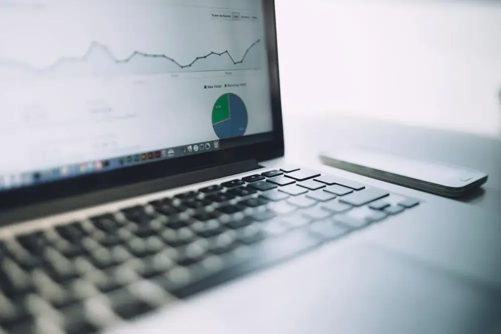A laptop displaying an analytics dashboard with charts.
